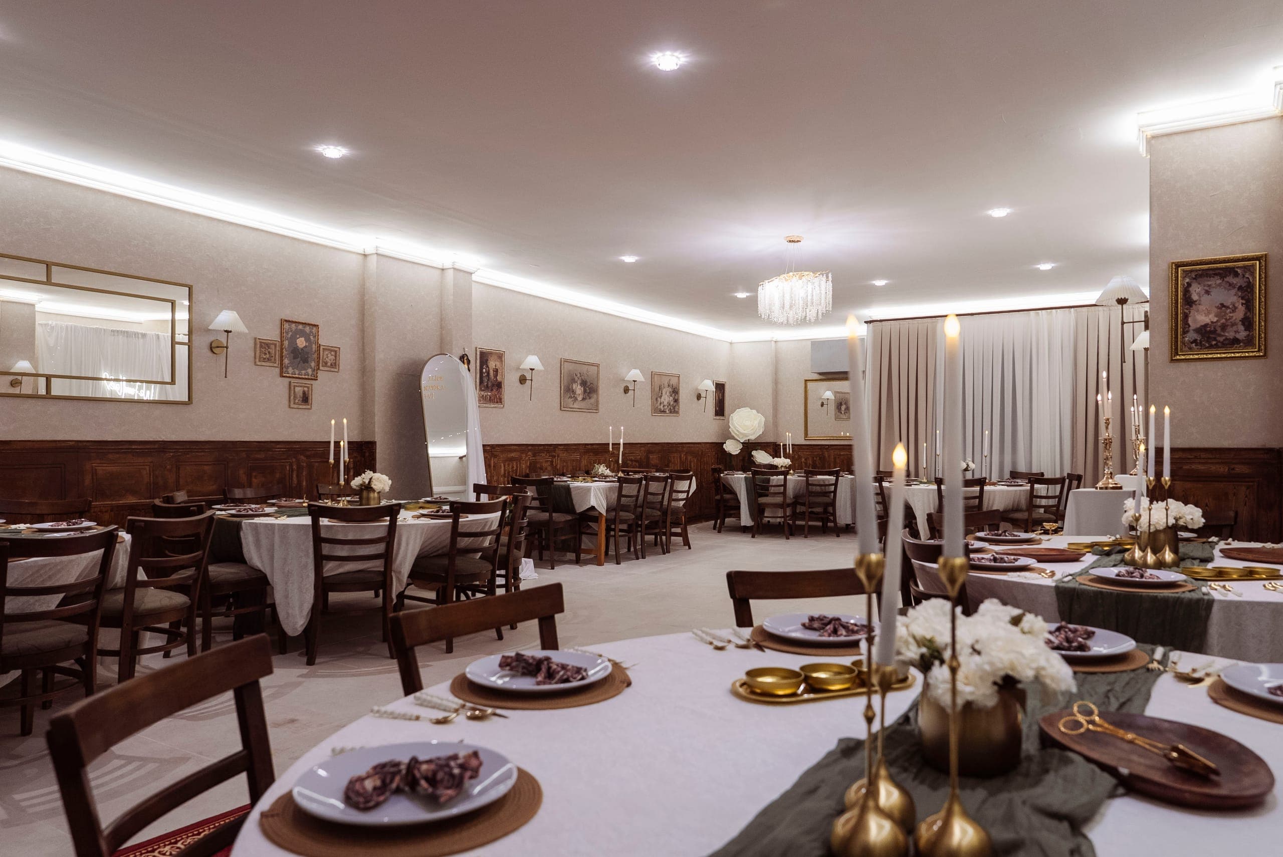 Alice Hatıra Evi ana salonu — adaçayı yeşili örtüler, altın detaylar ve kristal avize
